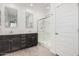 This bathroom has double sinks with a dark vanity, decorative mirrors, and glass enclosed shower at 14254 W Honeysuckle Dr, Surprise, AZ 85387