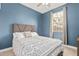 Comfortable bedroom with blue walls, a patterned comforter, and natural light from the window at 14254 W Honeysuckle Dr, Surprise, AZ 85387