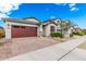 Well maintained single-story home featuring a brick driveway, two-car garage, and manicured landscaping at 14254 W Honeysuckle Dr, Surprise, AZ 85387