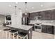 Modern kitchen features a granite island with stool seating and sleek stainless steel appliances at 14254 W Honeysuckle Dr, Surprise, AZ 85387
