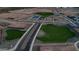 Aerial view of community green space with a playground and basketball court at 15660 W Deanne Dr, Waddell, AZ 85355