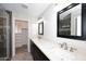 Bathroom featuring dual sinks, quartz countertops, dark cabinets and a walk-in closet at 1966 E Pebble Beach Dr, Tempe, AZ 85282