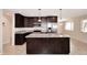 Modern kitchen with dark cabinets, granite countertops, stainless steel appliances and an island at 1966 E Pebble Beach Dr, Tempe, AZ 85282