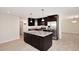 Spacious kitchen features dark cabinetry, stainless appliances, granite counters and an island with a sink at 1966 E Pebble Beach Dr, Tempe, AZ 85282