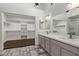 Beautiful bathroom featuring dual sinks, a quartz countertop, and a spacious walk-in closet at 19801 N 6Th Pl, Phoenix, AZ 85024