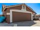 Side view of the two car garage with brown door and desert landscaping, ready to park your cars! at 19801 N 6Th Pl, Phoenix, AZ 85024