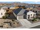 Aerial view of a single Gathering home with a gray tile roof, desert landscaping, and a two car garage at 20331 N Wagner Wash Dr, Buckeye, AZ 85396