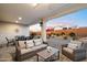 Outdoor patio featuring outdoor living room and dining areas, with tasteful neutral colors and hardscape at 20331 N Wagner Wash Dr, Buckeye, AZ 85396