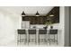 Modern kitchen features dark cabinets, a white countertop island with seating, and stylish pendant lighting at 20897 S 231St Pl, Queen Creek, AZ 85142