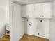 This laundry room features new vinyl flooring, white cabinets, and washer/dryer hookups at 2121 S Pennington -- # 58, Mesa, AZ 85202