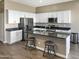 Modern kitchen featuring white cabinets, stainless steel appliances, dark countertops, and wood-look tile flooring at 22635 N Rummler Ln, Maricopa, AZ 85138