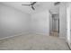 A bright empty room with carpet, ceiling fan, and access to another room at 23146 E Canary Way, Queen Creek, AZ 85142