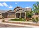 Attractive single-Gathering home featuring stone accents, a brick driveway, and a perfectly manicured front lawn at 23146 E Canary Way, Queen Creek, AZ 85142
