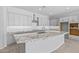 Modern kitchen showcasing gray cabinets, a large granite island, and stainless steel appliances at 23146 E Canary Way, Queen Creek, AZ 85142