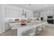 Modern kitchen showcasing gray cabinets, a large granite island, stainless steel appliances, and bar stool seating at 23146 E Canary Way, Queen Creek, AZ 85142