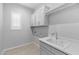White laundry room featuring a sink, cabinets, and a window with blinds at 23146 E Canary Way, Queen Creek, AZ 85142