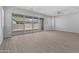 Bright living room with modern fan, wood-look tile floors, and sliding glass doors to the backyard at 23146 E Canary Way, Queen Creek, AZ 85142
