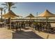 Outdoor community seating area with tables, chairs, and shade umbrellas overlooking the lake at 23146 E Canary Way, Queen Creek, AZ 85142