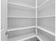 Bright, white pantry with numerous shelves and neutral floors at 23146 E Canary Way, Queen Creek, AZ 85142