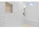 Close-up of the bright white-tiled shower with built-in niche and a shower bench at 23146 E Canary Way, Queen Creek, AZ 85142