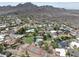 Aerial view of the neighborhood showing the tennis court, swimming pool, and nearby mountains at 2818 E Malapai Dr, Phoenix, AZ 85028