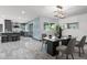 Modern dining area with view to the kitchen, featuring contemporary lighting and stylish decor at 2818 E Malapai Dr, Phoenix, AZ 85028