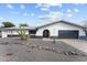 Contemporary home showcasing desert landscaping, a gray driveway and black garage doors at 2818 E Malapai Dr, Phoenix, AZ 85028