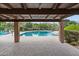 Beautiful pool with clear water, viewed through a covered patio area with desert landscaping and mountain views in the background at 2818 E Malapai Dr, Phoenix, AZ 85028