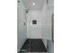 Modern walk-in shower featuring textured white tile walls, a glass door, and matte black fixtures at 2818 E Malapai Dr, Phoenix, AZ 85028