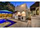 Outdoor kitchen and pool area with a built-in grill and counter space for entertaining at 31 E Bishop Dr, Tempe, AZ 85282