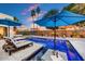 A serene pool area with lounge chairs, umbrellas, and a tiled waterfall feature at 31 E Bishop Dr, Tempe, AZ 85282