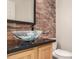 Powder room features modern vessel sink, stone countertop, and accent brick wall at 333 N Pennington Dr # 63, Chandler, AZ 85224