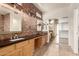 Bathroom featuring a brick accent wall, dual sinks, and wood cabinets at 333 N Pennington Dr # 63, Chandler, AZ 85224