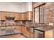 Updated kitchen with wood cabinets, granite counters, stainless steel appliances and brick backsplash detail at 333 N Pennington Dr # 63, Chandler, AZ 85224
