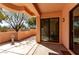 A covered patio with desert landscaping, stucco walls, and glass sliding doors to the interior at 333 N Pennington Dr # 63, Chandler, AZ 85224
