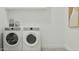 Modern laundry room showcasing side-by-side washer and dryer units, decorative vases, and a minimalist art piece at 3783 E Gold Mountain Ave, San Tan Valley, AZ 85143