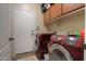 Well-equipped laundry room with front loading machines, upper cabinets, and a utility sink at 3818 N Kalispell Ct, Casa Grande, AZ 85122