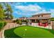 View of the backyard featuring a putting green, pool, outdoor kitchen, and patio at 4297 E Pyrenees Ct, Gilbert, AZ 85298