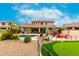 A beautiful backyard featuring a pool, outdoor kitchen, patio, and putting green at 4297 E Pyrenees Ct, Gilbert, AZ 85298