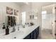 Bathroom vanity area with double sink, large mirror, and blue-painted cabinets at 4297 E Pyrenees Ct, Gilbert, AZ 85298