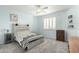Relaxing bedroom with cozy gray carpet, a ceiling fan, and plenty of natural light coming in from the window at 4297 E Pyrenees Ct, Gilbert, AZ 85298