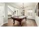 Billiards room featuring a pool table, elegant chandelier, and staircase, exuding sophistication at 4297 E Pyrenees Ct, Gilbert, AZ 85298