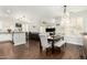 Dining area with dark wood floors, pendant lighting, and seamless flow to the kitchen and living room at 4297 E Pyrenees Ct, Gilbert, AZ 85298