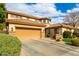 View of the home showcasing the two-car garage, driveway, desert landscaping, and unique architectural details at 4297 E Pyrenees Ct, Gilbert, AZ 85298