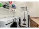 Organized laundry room with front loading washer and dryer, folding counter and storage shelves at 4297 E Pyrenees Ct, Gilbert, AZ 85298