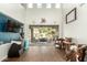Bright living room with dark wood floors, high ceilings, a large sliding glass door, and eclectic decor at 4297 E Pyrenees Ct, Gilbert, AZ 85298