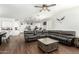 Open concept living space with dark wood floors, a large sectional sofa, and seamless flow to the kitchen at 4297 E Pyrenees Ct, Gilbert, AZ 85298