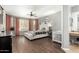 Spacious main bedroom featuring hardwood floors, a ceiling fan, updated lighting, and a vanity space with an adjacent bathroom at 4297 E Pyrenees Ct, Gilbert, AZ 85298