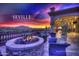 Inviting outdoor patio with a cozy stone fire pit, comfortable seating, and scenic sunset views at Seville Golf & Country Club at 4297 E Pyrenees Ct, Gilbert, AZ 85298