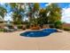 Backyard in-ground pool with brick surround, landscaping, and outdoor seating at 4297 E Pyrenees Ct, Gilbert, AZ 85298